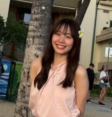 南国の木の前で、髪に花を飾って笑う叶愛